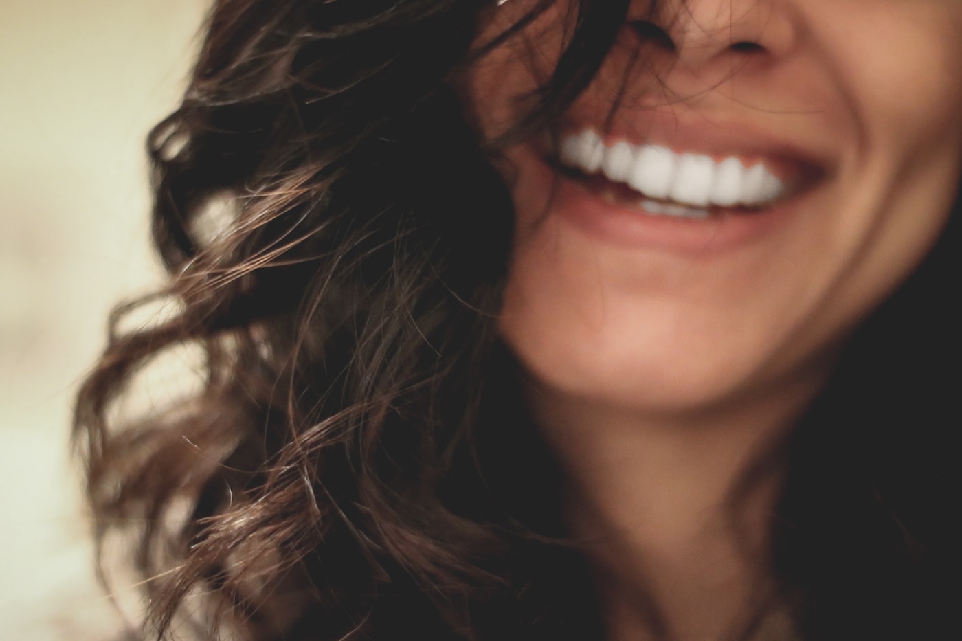 Close-up de um sorriso genuíno e saudável, iluminado por luz natural